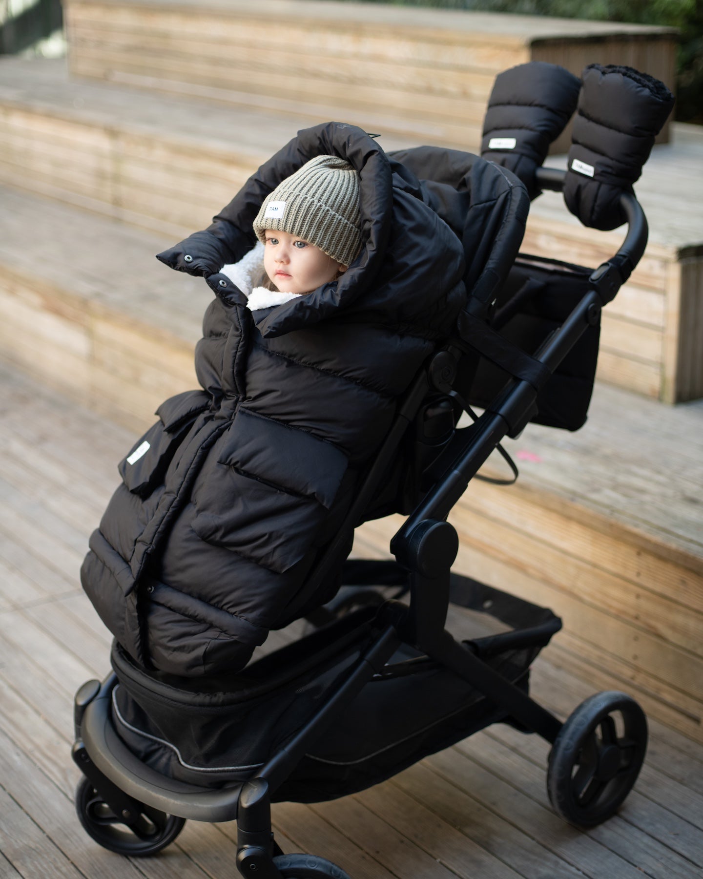 bébé dans une chancelière attachée à une poussette